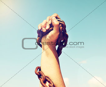 female hand is lifted up and bound by an iron chain 