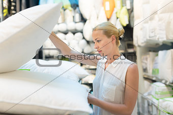 Woman choosing the right item for her apartment in a modern home furnishings store.