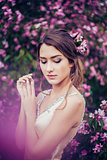 Portrait of young beautiful woman posing in spring blossom trees.