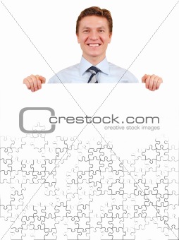 Confident business man holding a white puzzle board for copy-spa