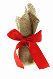 gift box wrapped by burlap canvas with red bow