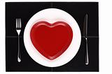 empty white and red heart plates with a knife and fork on a blac