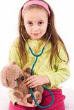 Adorable little girl playing doctor with a teddy bear