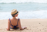 Young girl takes a sun bath on a sandy beach