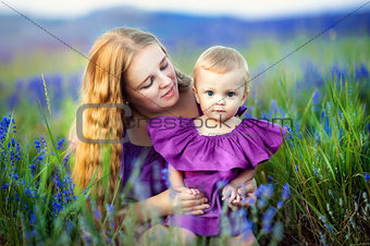 Lifestyle portrait mom and daughter in happines at the outside in the meadow