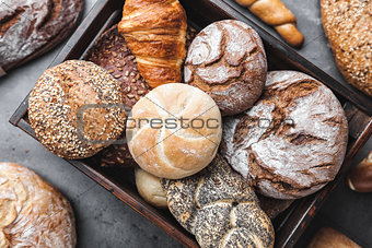 A basket full of delicious fresh bread on wooden background