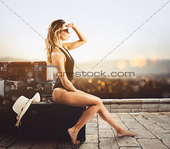 Young woman sitting on luggage waiting to go for a vacation