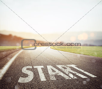 Start written to the ground on a road at sunset