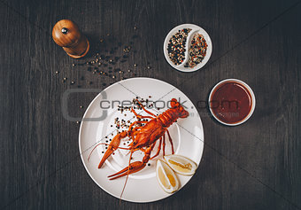 Food concept. Boiled big red fresh crawfish in white plate with lemon slices