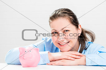 Happy young woman with a piggy bank pink