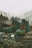 Hiking boots with knife and compass on tree log
