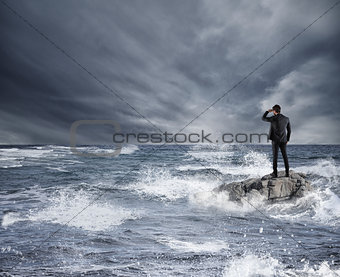 Businessman looking for the future during storm in the sea. Concept of economic crisis and problem