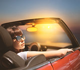 Young woman in cabriolet car near sea