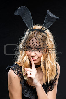 Sexy young blonde with ears hare on a black background
