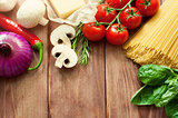 Italian food or ingredients background with fresh vegetables, pasta, cheese parmesan and spices. Top view, view from above. Copy space. Dark background.