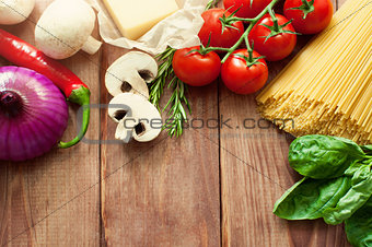 Italian food or ingredients background with fresh vegetables, pasta, cheese parmesan and spices. Top view, view from above. Copy space. Dark background.