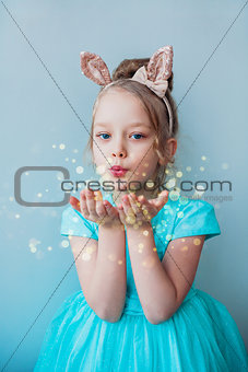 Cute little girl blowing magical dust.