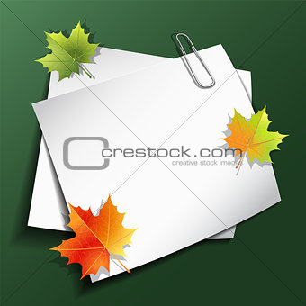 Paper sheets and maple autumn leaves.