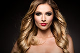 Beautiful blonde model girl with long curly hair . Hairstyle wavy curls . Red lips.