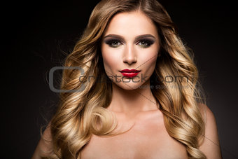 Beautiful blonde model girl with long curly hair . Hairstyle wavy curls . Red lips.