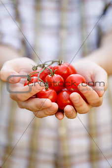 Young man with cherry tomatoes