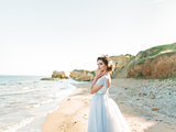 Romantic beautiful bride in luxury dress posing on the beach.