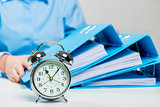 Close-up alarm clock and business documents out of focus