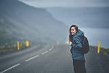 a woman tourist on the empty road on the fjord in Iceland