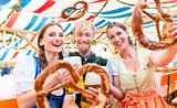 Friends with giant pretzels in Bavarian beer tent