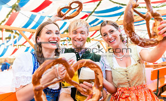 Friends with giant pretzels in Bavarian beer tent