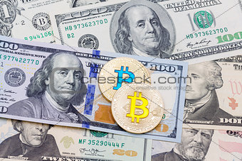 Bitcoln coins and US dollars, close up.