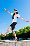 Asian woman standing on one leg outdoors