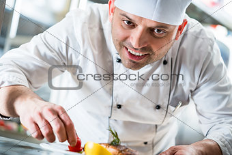 Chef garnishing the food on plate to complete the dish