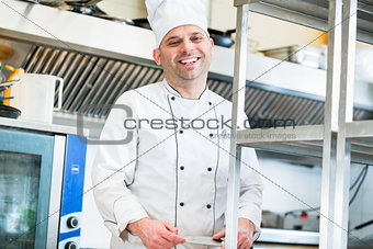 Chef or cook in hotel kitchen cooking dishes