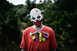 scary evil clown in the woods