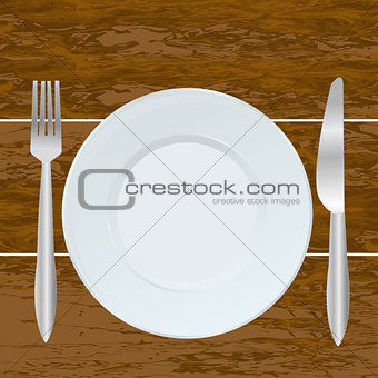 Empty plate, fork and knife on the  wood background