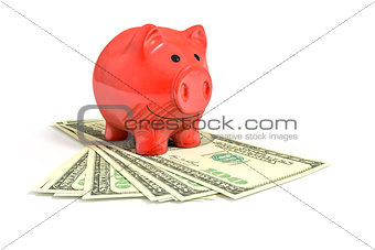 a red piggy bank over dollar notes
