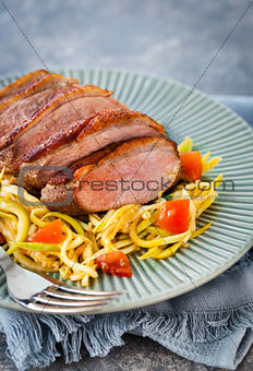 Roasted duck breast and zucchini noodles with tomatoes