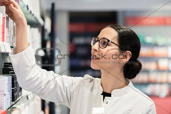 pharmacist standing in front of various products thinking to mak