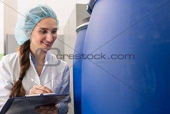 Manufacturing employee writing report during quality control in