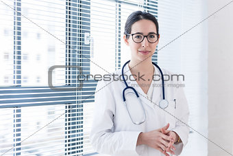 Portrait of a young nurse or physician looking at camera with co