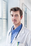 Portrait of a young serious doctor looking at camera with determ