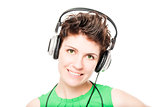 smiling woman with headphones listening favorite music on a whit