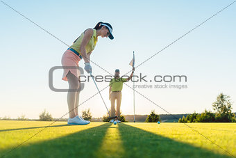 Fit woman exercising hitting technique during golf class with an