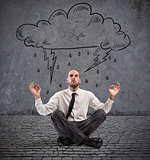Businessman practice yoga under a rainy cloud