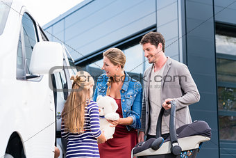 Family checking new car in car dealership