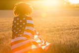 Girl Teenager Wrapped in USA Flag in Field at Sunset