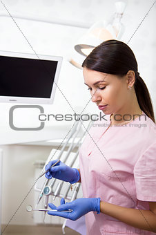 Happy young female dentist over medical office background