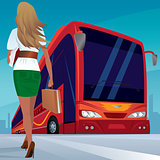 Young adult woman walks to red passenger bus