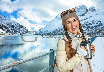 tourist woman with thermos travel mug in winter outdoors